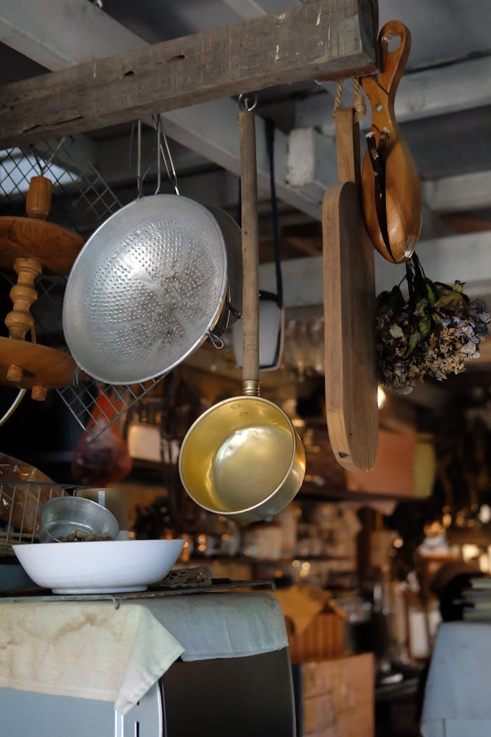 Vintage kitchen utensils hanging with warm lighting creating a cozy atmosphere.